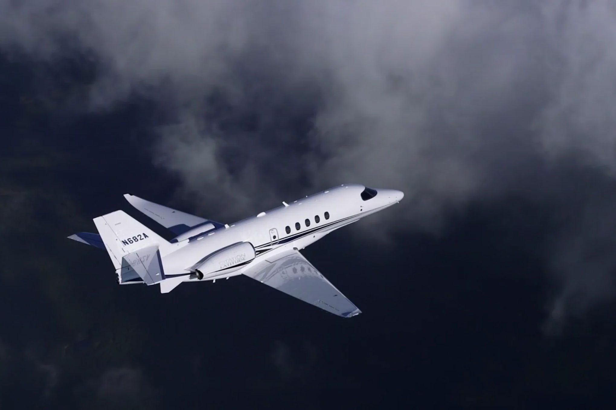 Cessna Citation Latitude in flight against dark storm cloud