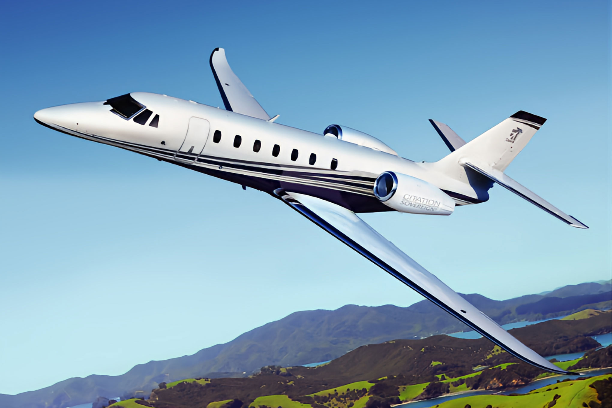 Cessna Citation Sovereign+ in flight over coastal hills