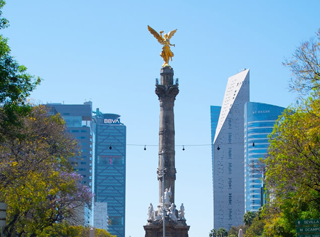 Mexico City: The gilded Angel of Independence on its column, framed by glass office towers and green trees