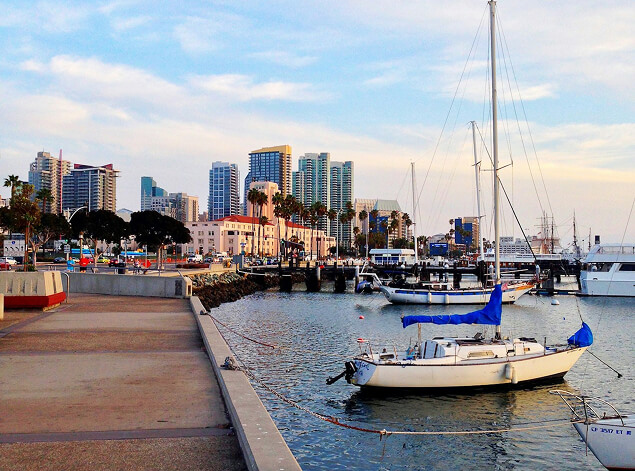 San Diego: Sailboats moored along the downtown San Diego embarcadero, the waterfront skyline behind under blue sky
