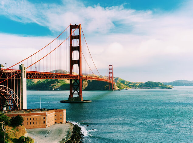 San Francisco: The Golden Gate Bridge from the Presidio side, its towers in low cloud above the bay