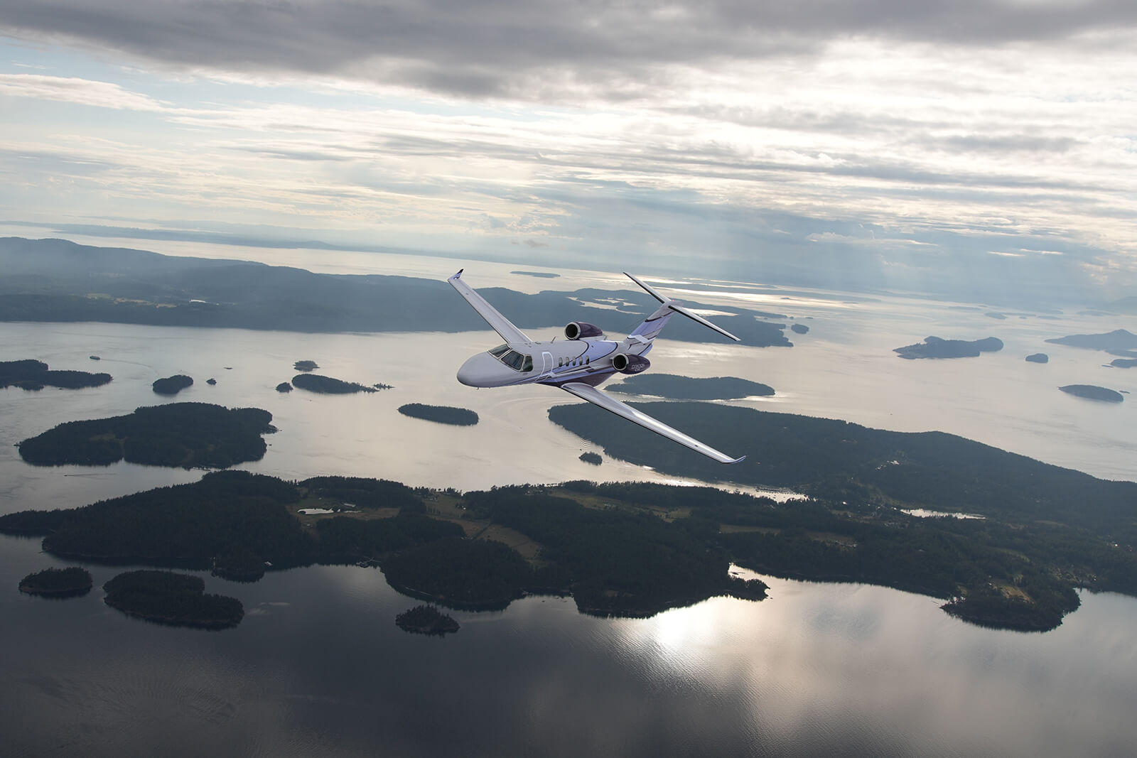 Cessna Citation CJ3 in flight above islands and open water