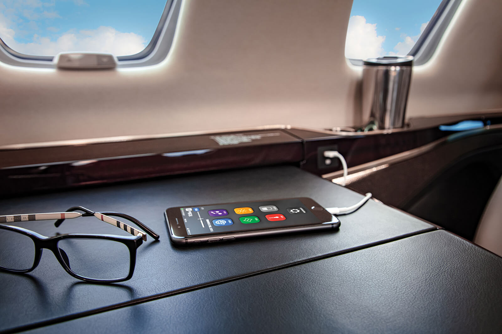 Cessna Citation CJ3 cabin side ledge with a phone and reading glasses