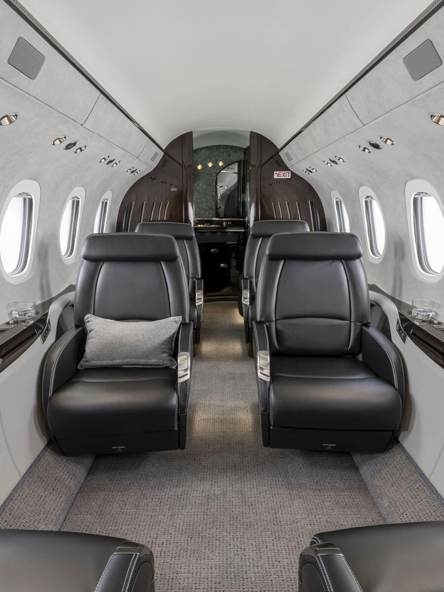 Cessna Citation Latitude cabin aisle with black leather seats, portrait view