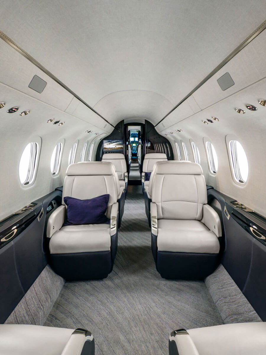 Cessna Citation Longitude cabin aisle with cream leather seats, portrait view