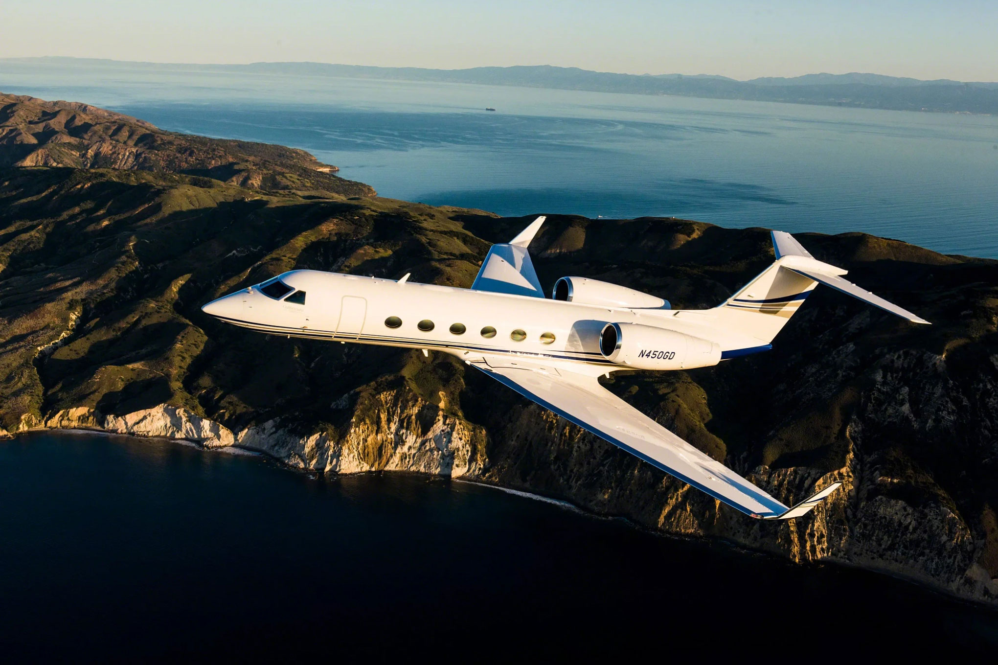 Gulfstream G450 in flight over coastal cliffs