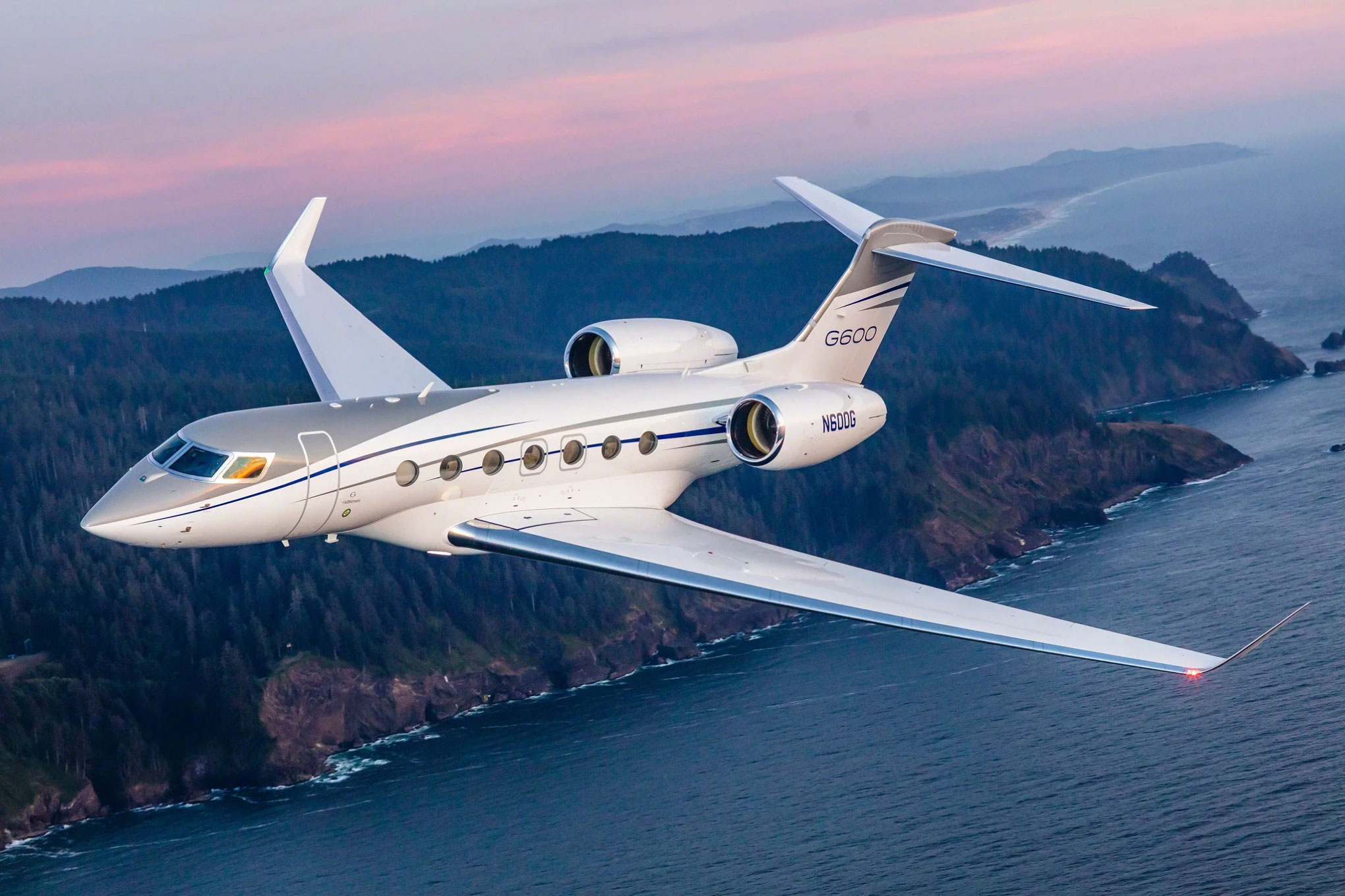 Gulfstream G600 in flight over a coastline at dusk