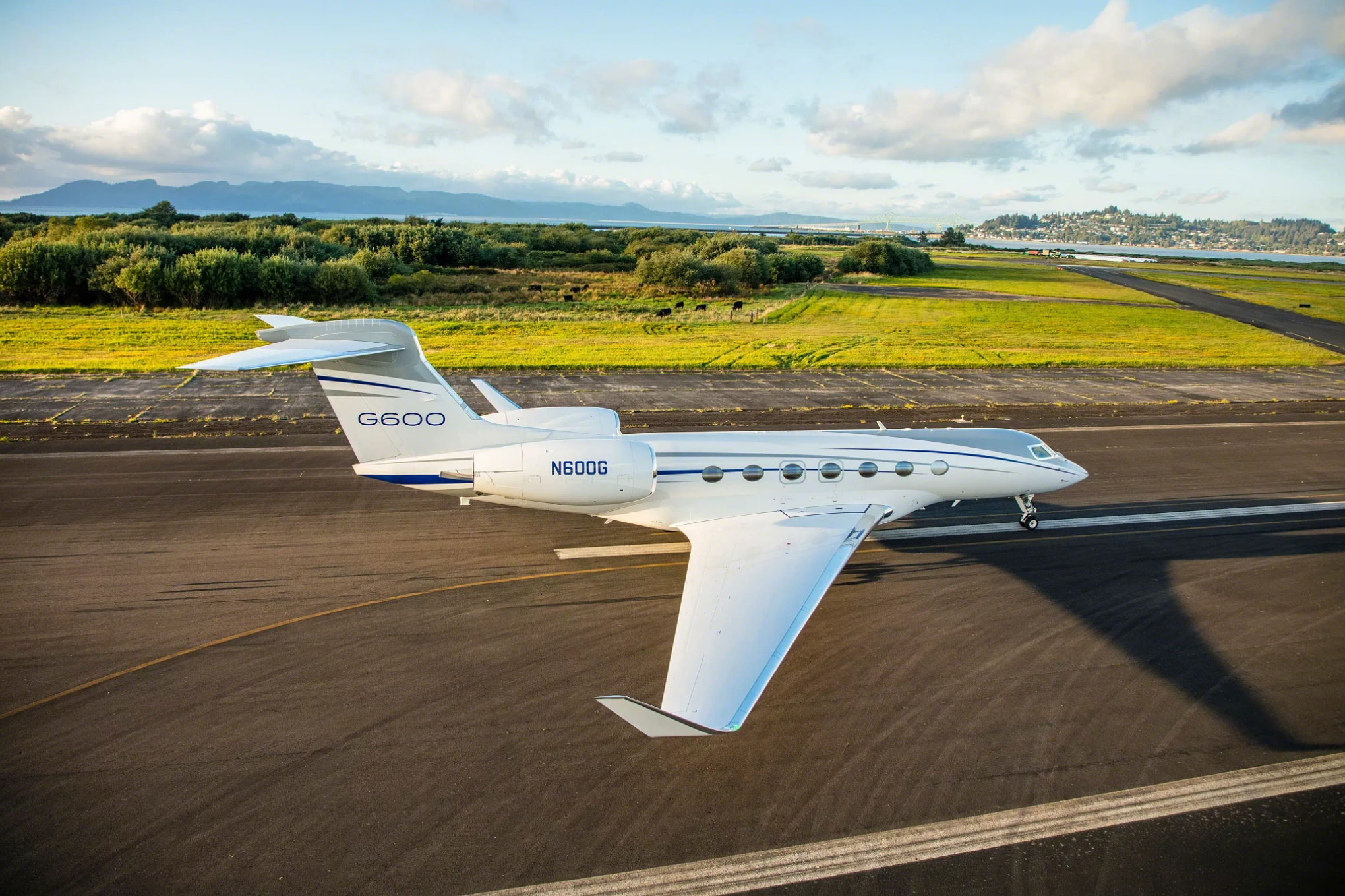 Gulfstream G600 taxiing past open grassland