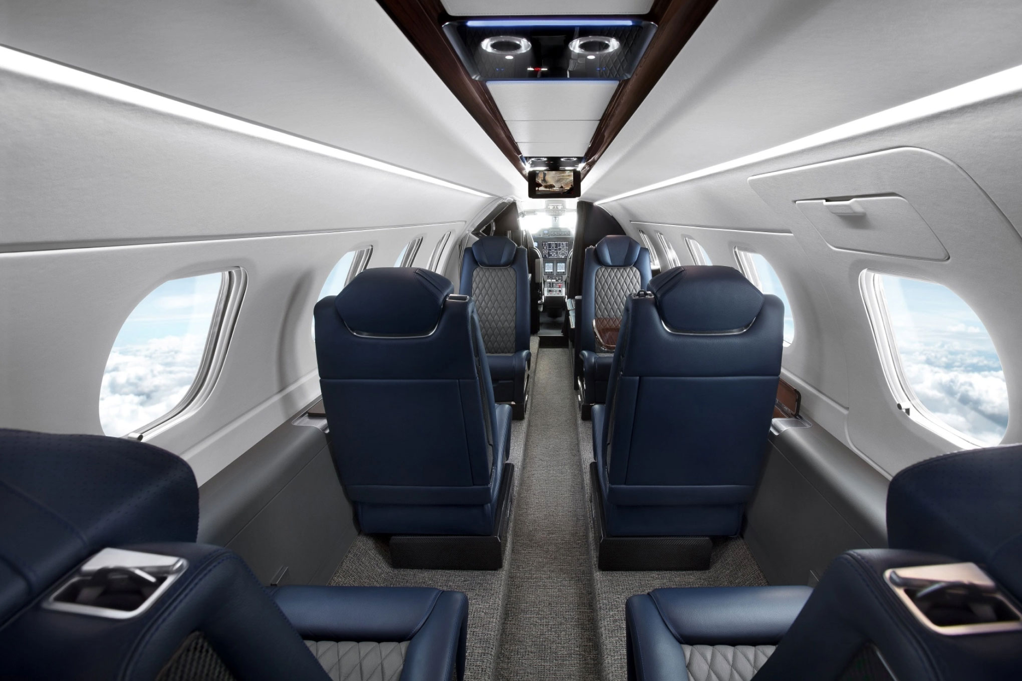 Embraer Phenom 300E cabin with navy leather club seats facing each other
