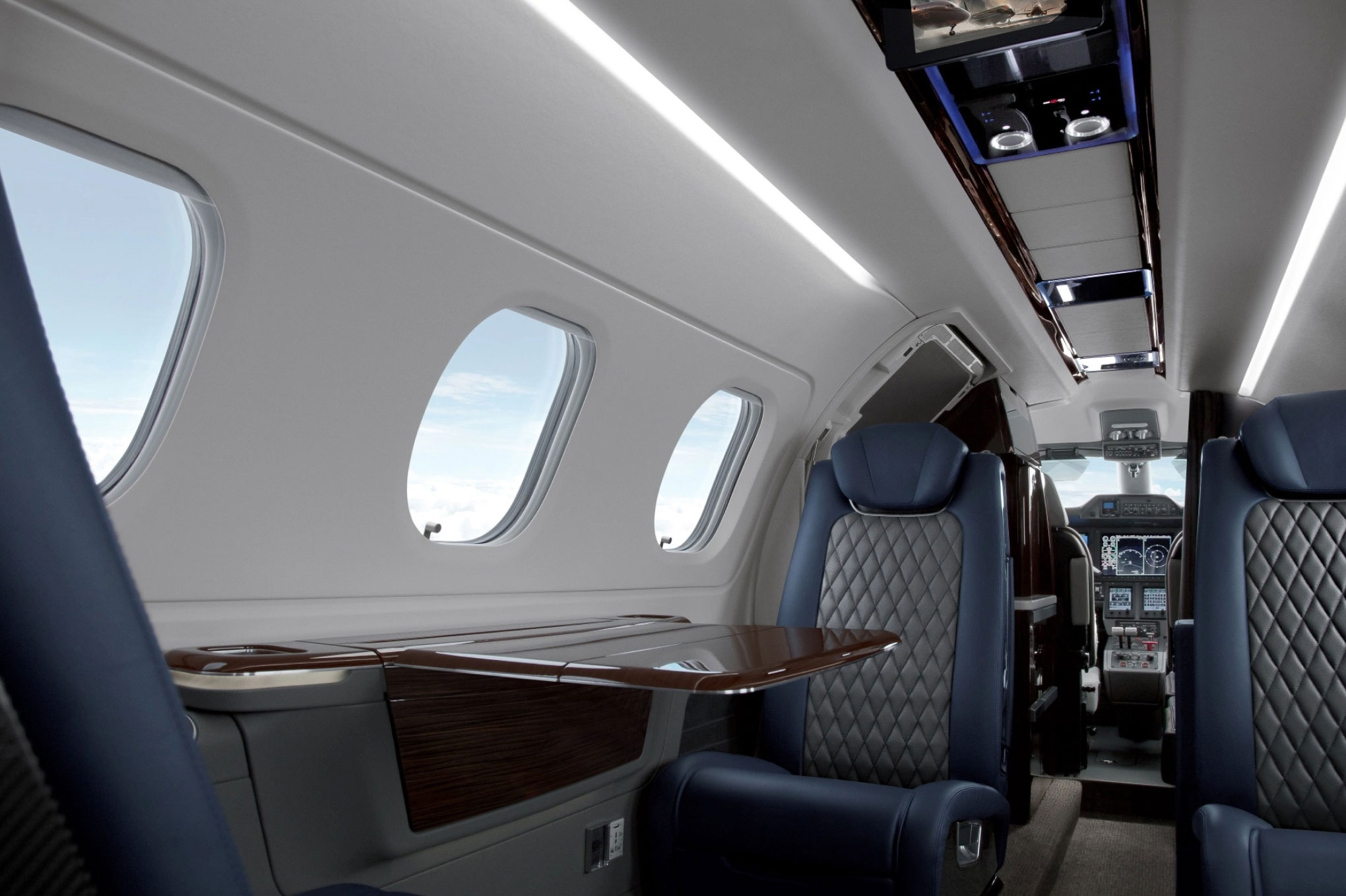 Embraer Phenom 300E cabin window seat looking toward the cockpit