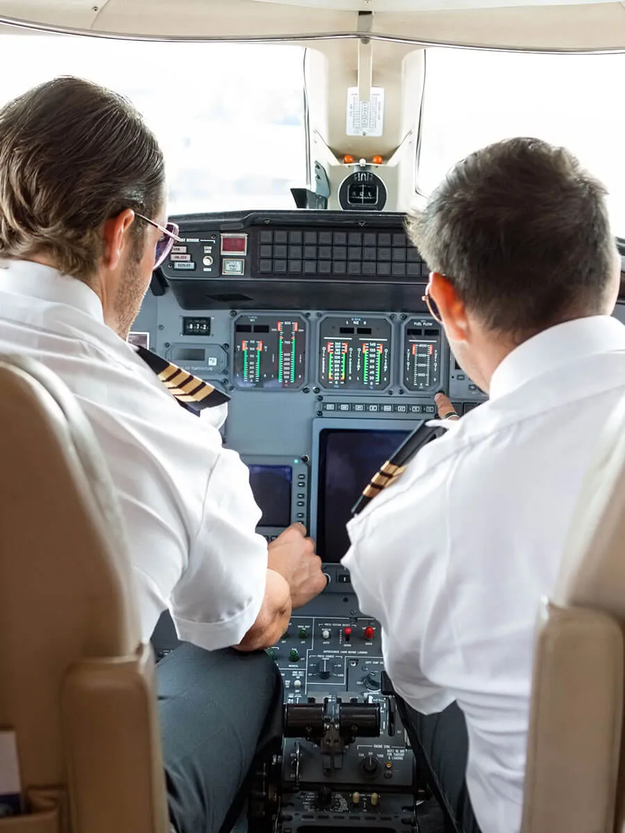 Two pilots at the controls on a private jet flight deck