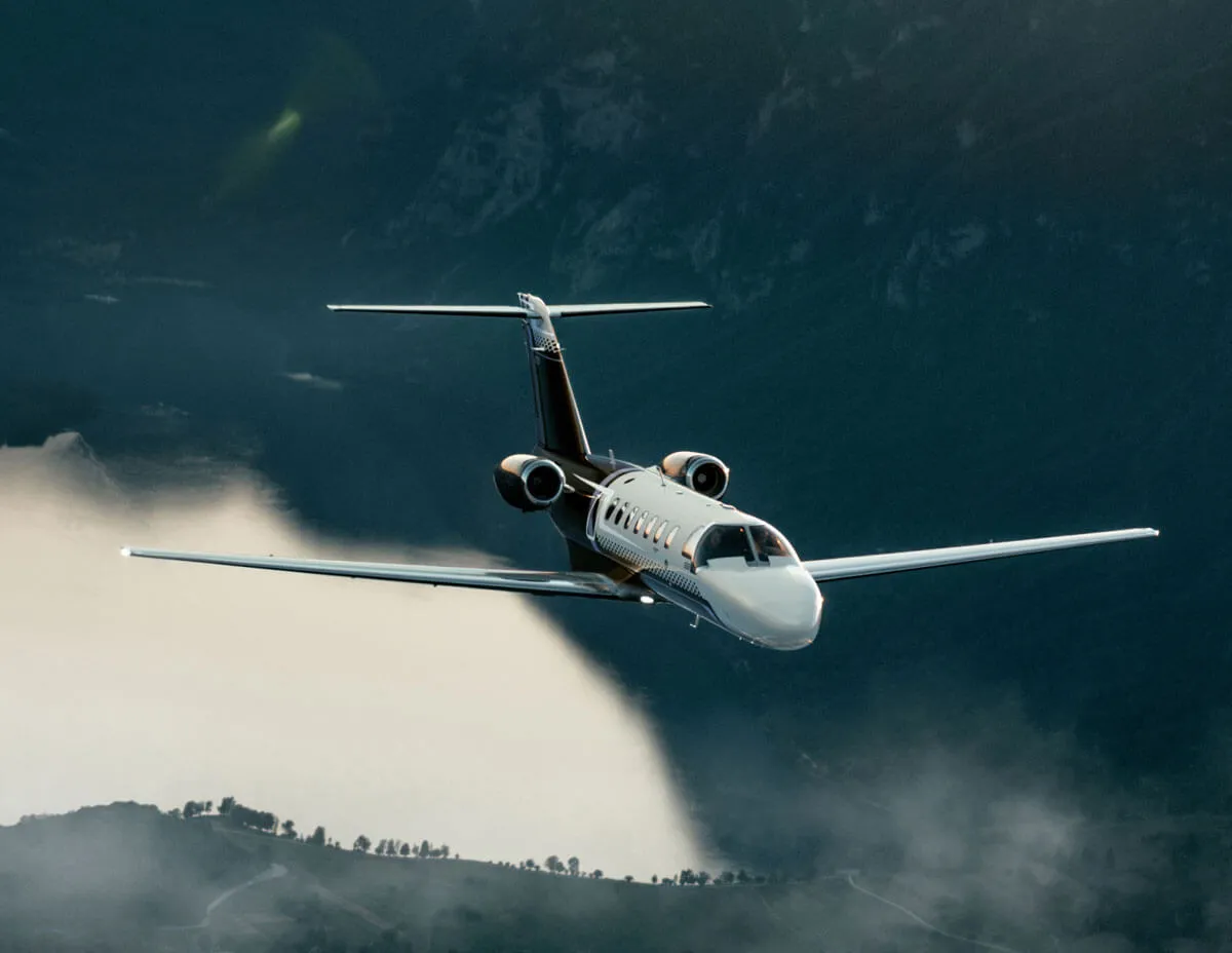 Cessna Citation light jet in flight above low cloud