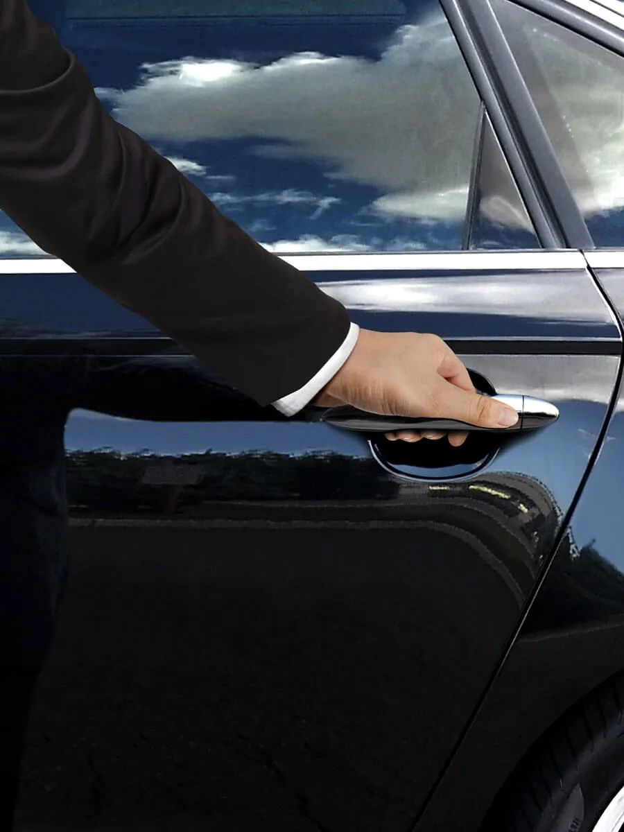 Chauffeur opening a car door for an arriving passenger