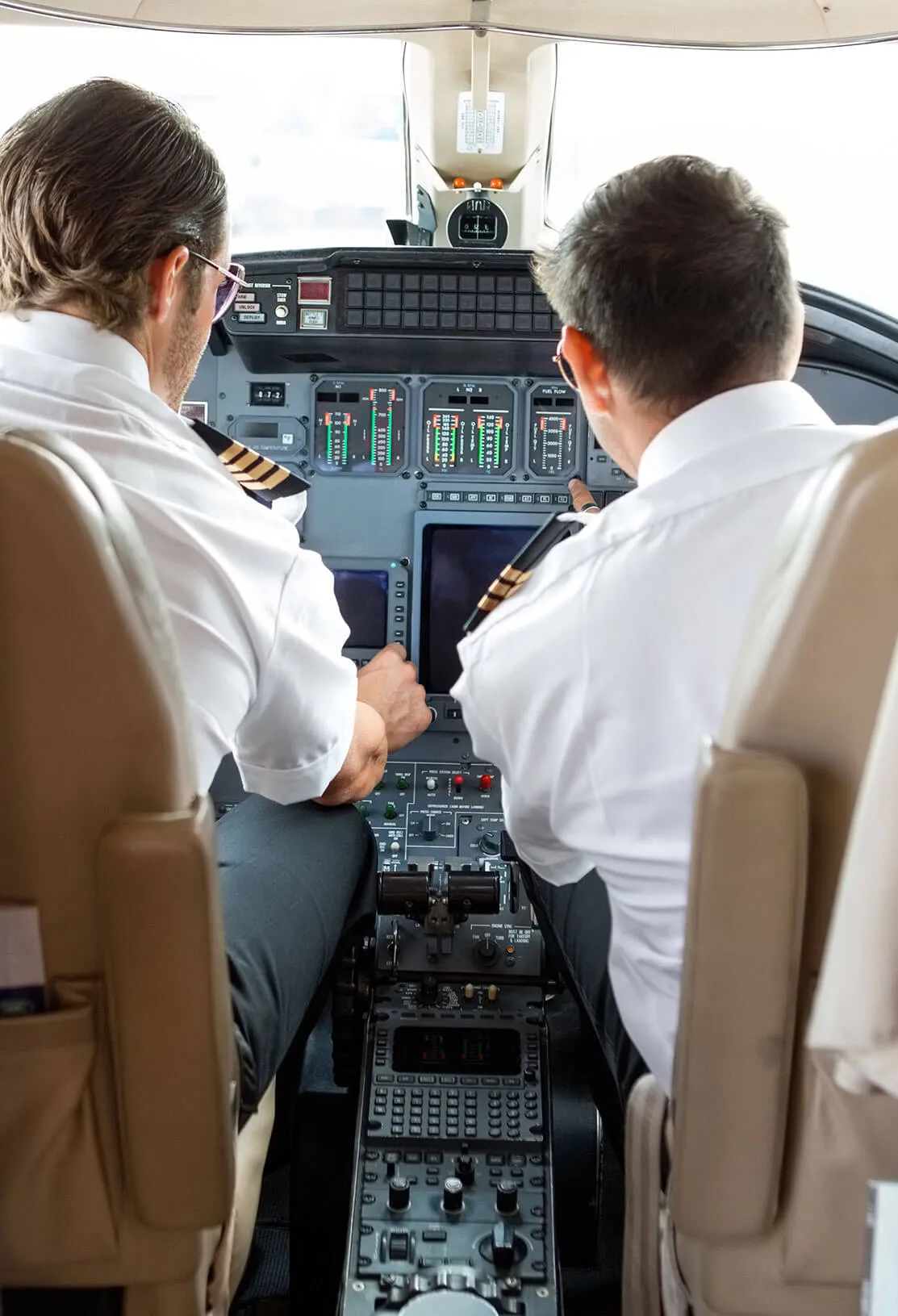 Two pilots at the controls on a private jet flight deck