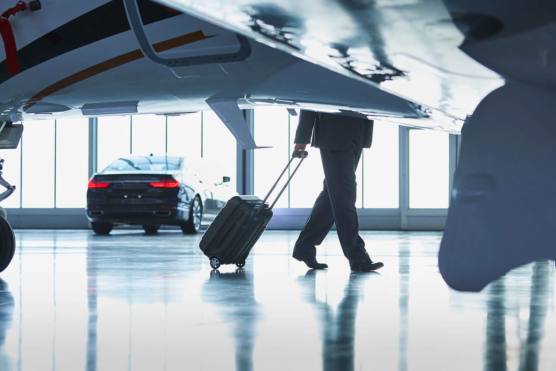 Fractional owner walking with luggage to a private jet in the hangar